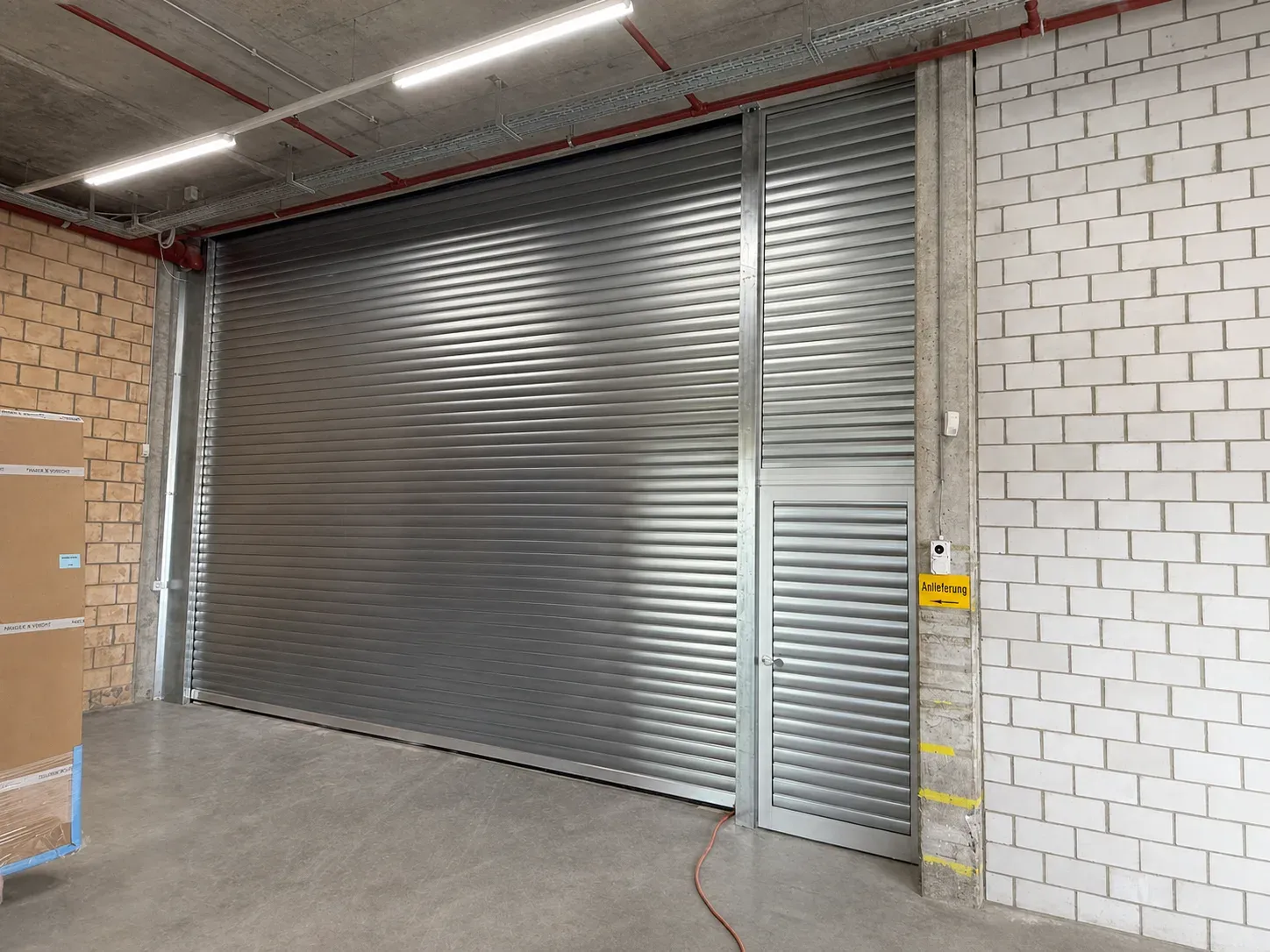 Rolltor STP-RT-60 mit separater Nebentür und Metall-Unterkonstruktion bei Kraft E.L.S. AG in Effretikon