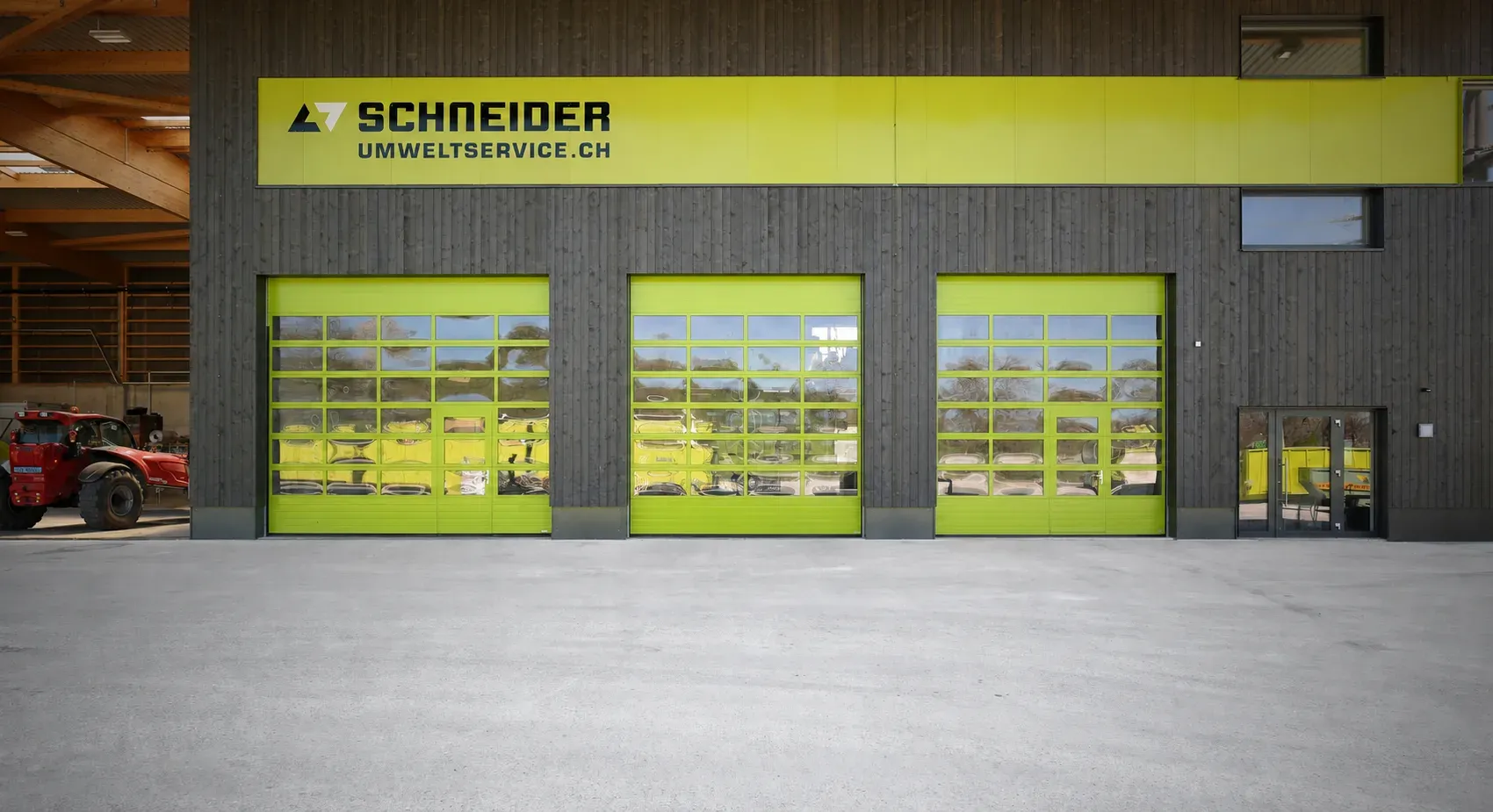 Drei lemonfarbene Sektionaltore mit Fensterfeldern unter dem Schriftzug von Schneider Umweltservice