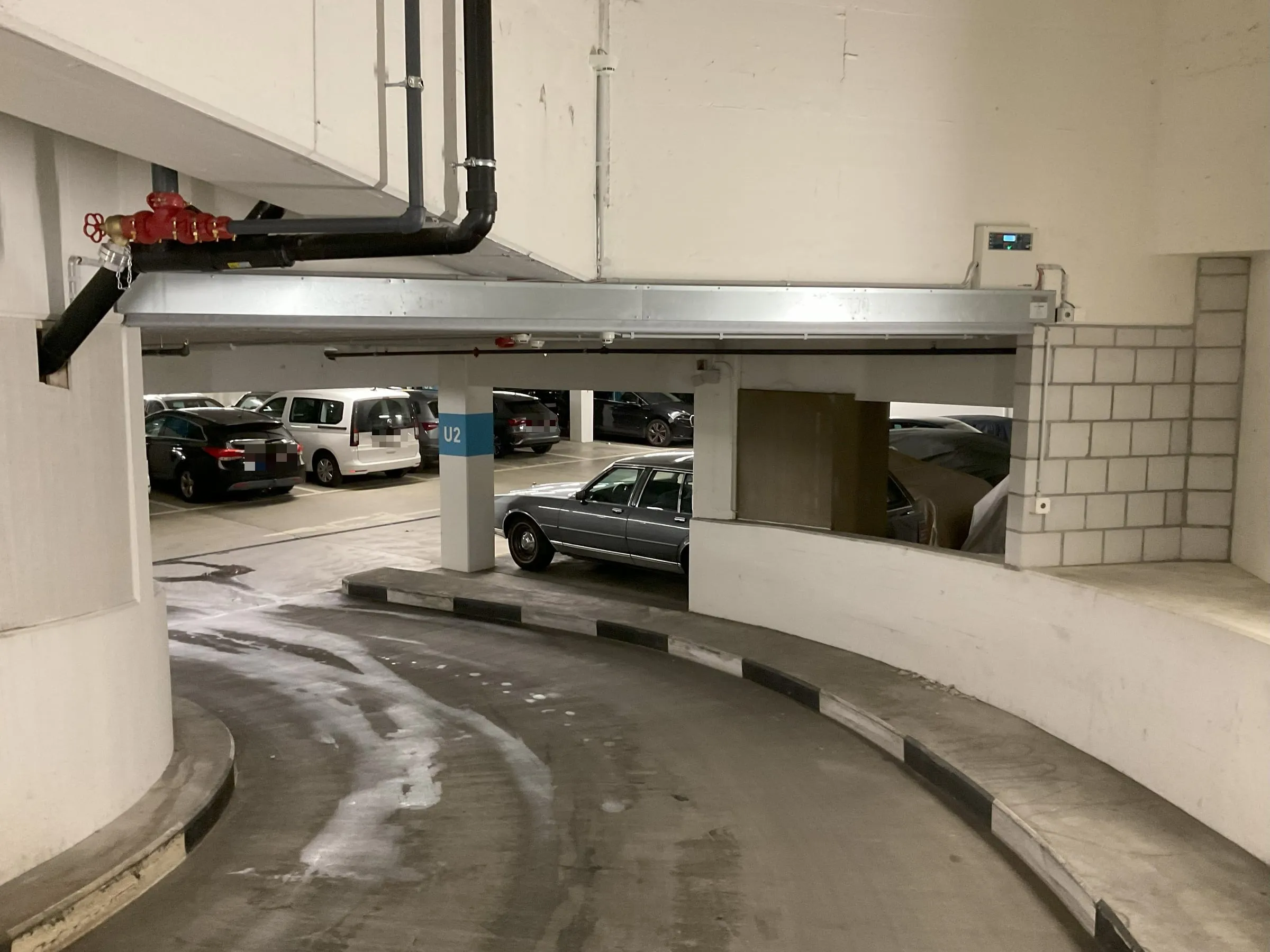 Kopfbox und seitliche Führung eines eingefahrenen Vorhangsystems über einer Parkhauszufahrt in Bern
