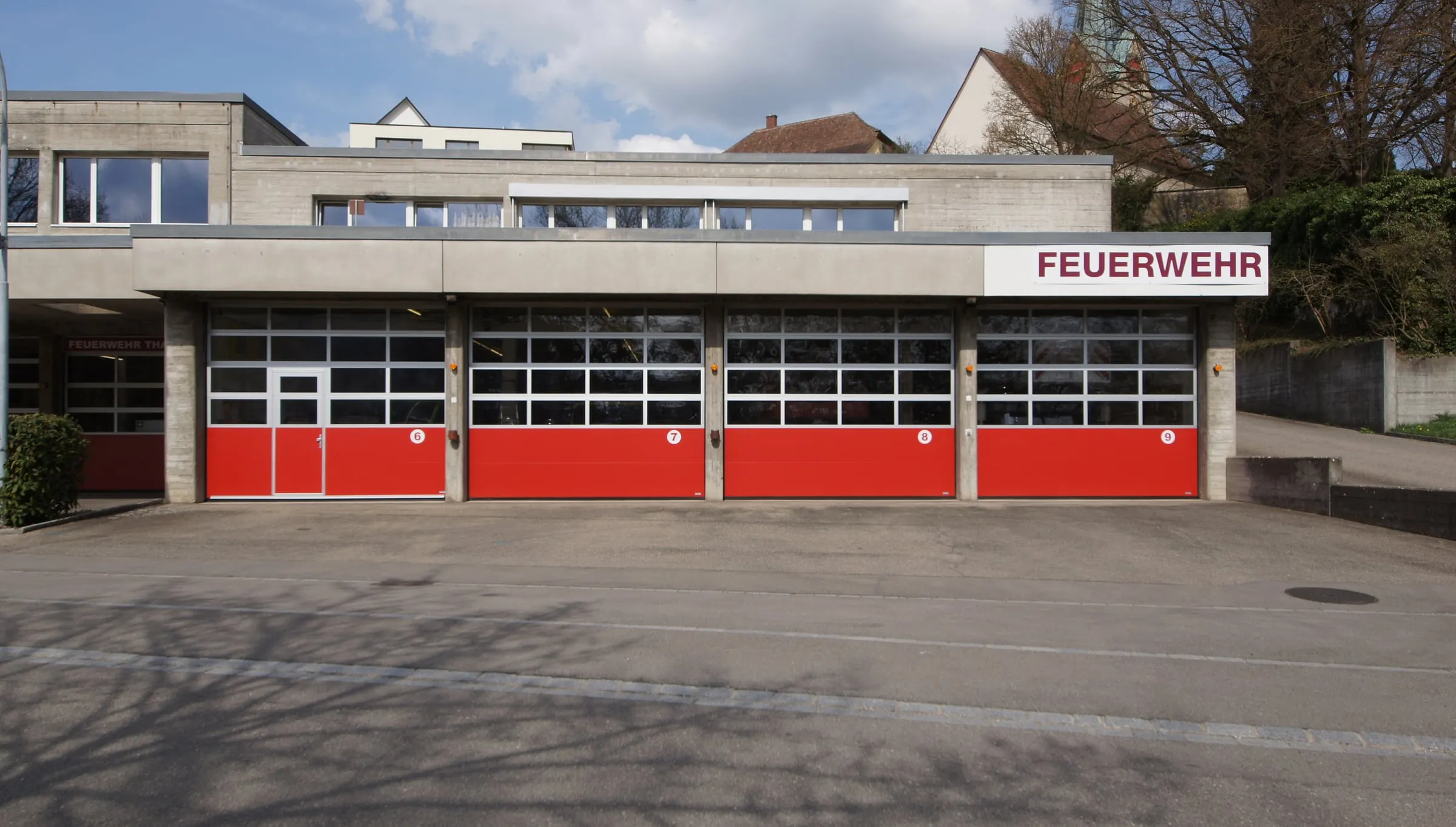 Frontale Torreihe mit roten Sektionaltoren am Feuerwehrlokal Thayngen
