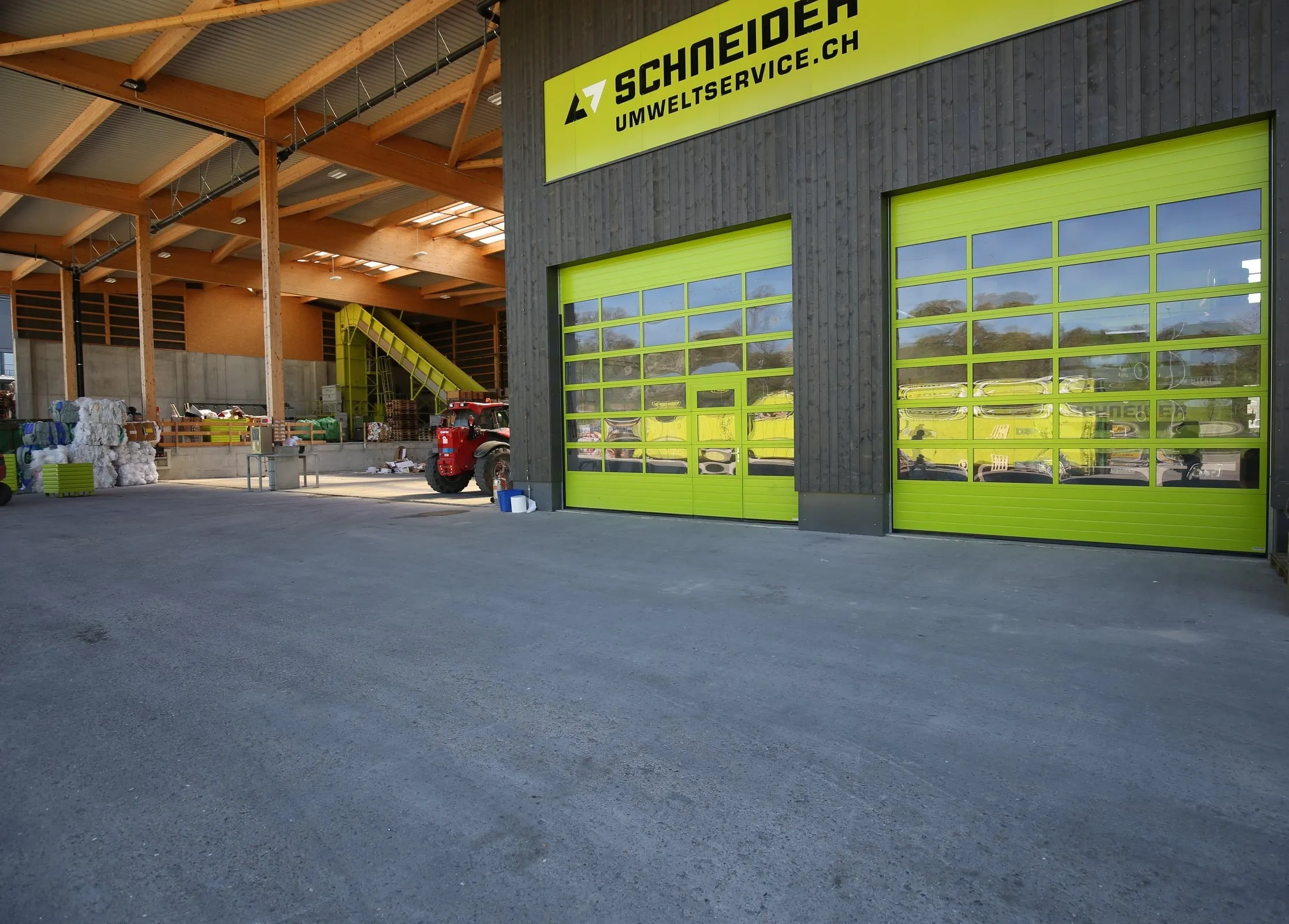 Blick durch ein geöffnetes Sektionaltor in die Halle von Schneider Umweltservice in Volketswil