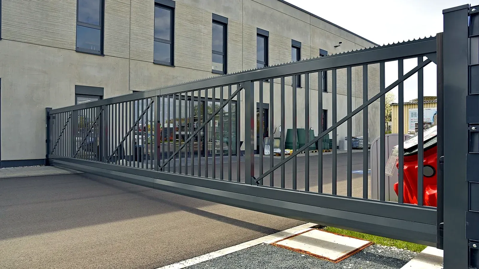 Freitragendes Arealschiebetor mit Gitterfüllung an einer Zufahrt
