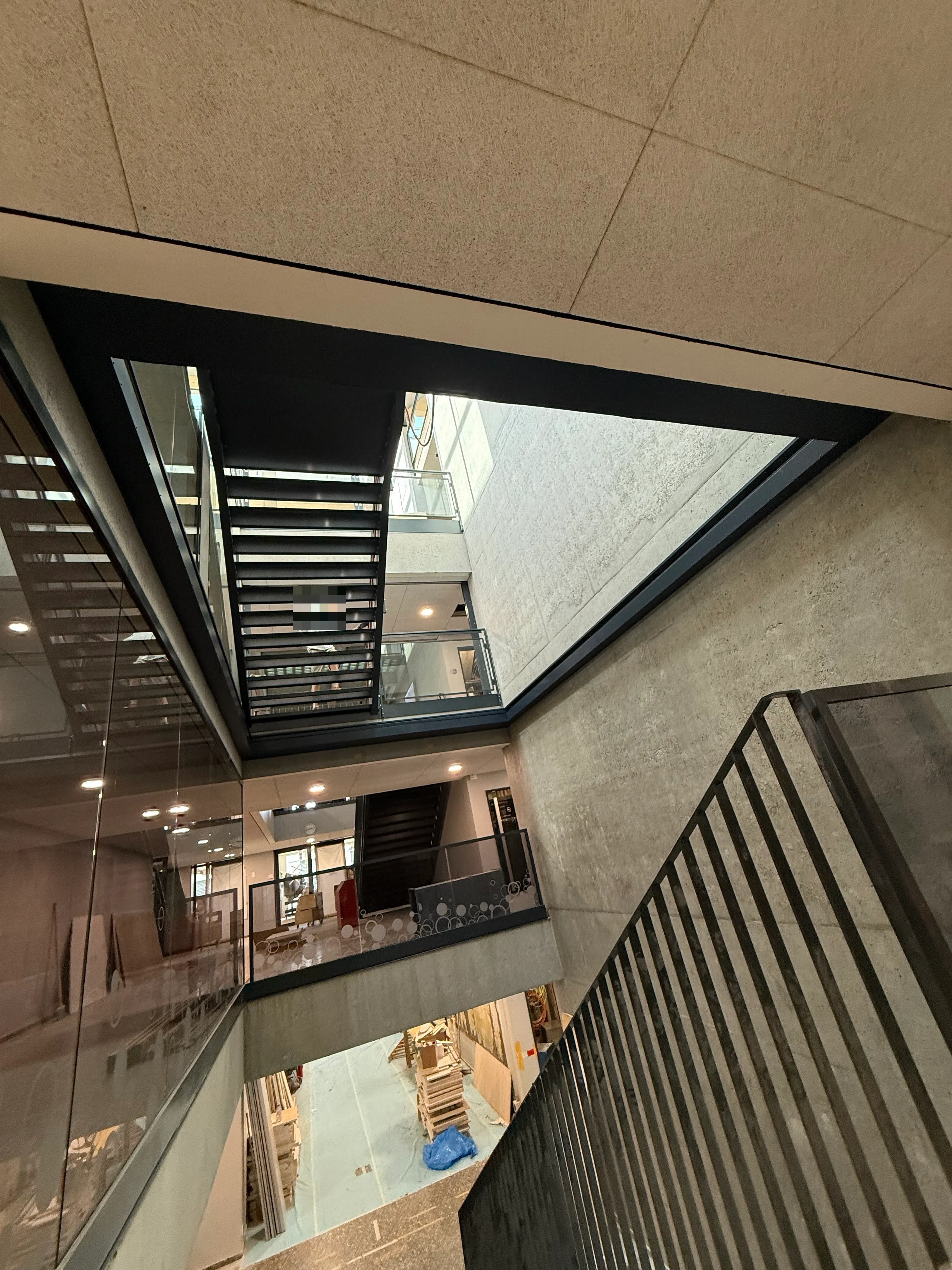 Offene Treppenhausöffnung mit zurückgezogenem horizontalem Brandschutzvorhang in der Schulerweiterung Zumikon