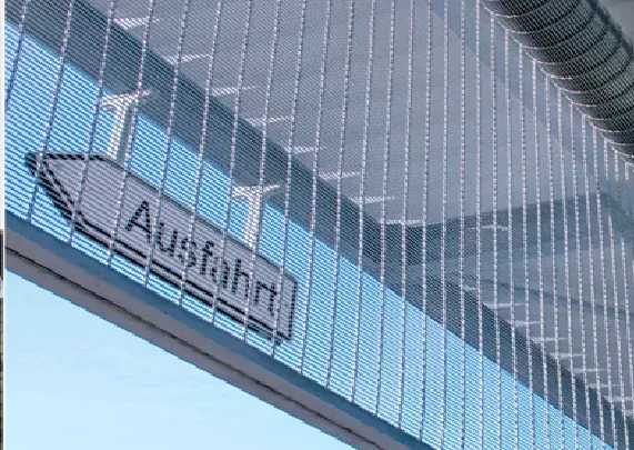 Detail eines Rolltors aus Edelstahl-Architekturgewebe an einer Parkhaus-Ausfahrt