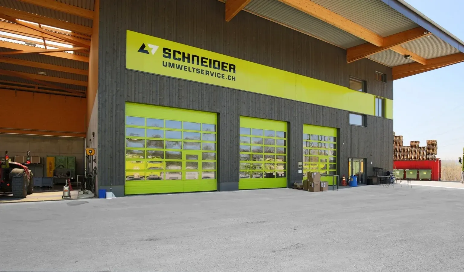 Werksgebäude von Schneider Umweltservice in Volketswil mit lemonfarbenen Sektionaltoren