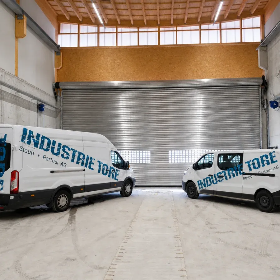 Individuell gefertigtes, grossformatiges Industrie-Rolltor in einer hohen Halle mit Holztragwerk